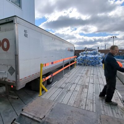 Worker removing TrukRail after flatbed has been loaded.